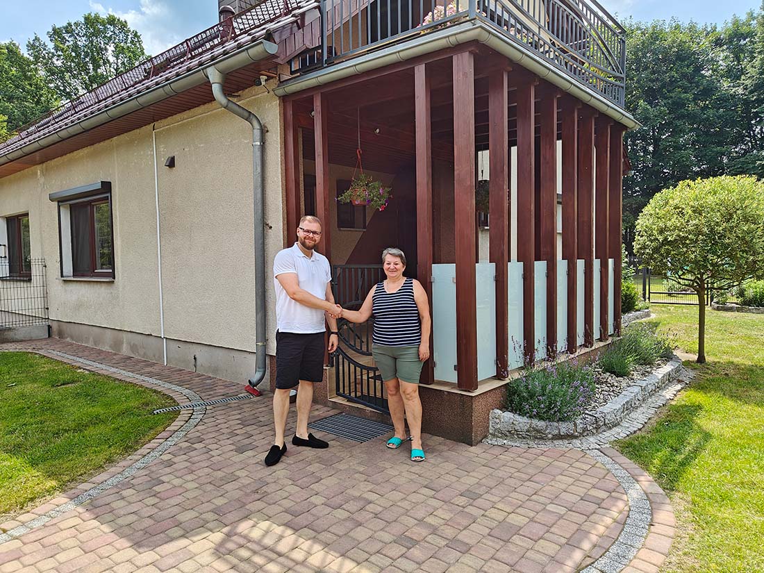 Na zdjęciu widzimy klientkę Husar Energia Opole, która wita nas w swoim domu, w którym zamontowaliśmy pompę ciepła.